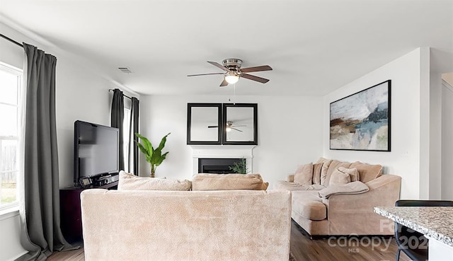 living room featuring ceiling fan and dark hardwood / wood-style flooring