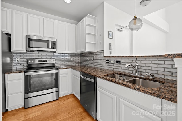 kitchen featuring white cabinets, decorative light fixtures, sink, and stainless steel appliances