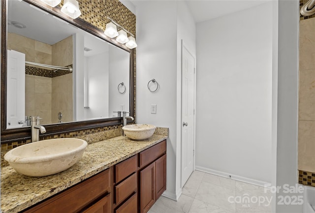 bathroom featuring tiled shower and vanity