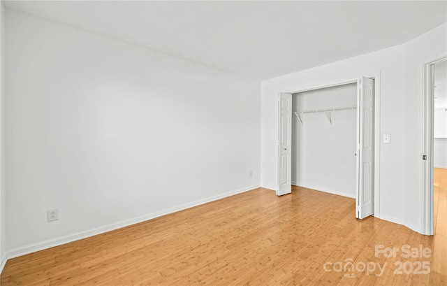 unfurnished bedroom with wood-type flooring and a closet