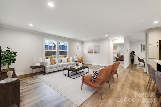 living room with ornamental molding and light wood-type flooring