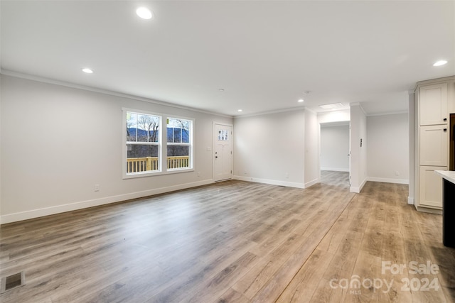 unfurnished living room featuring light hardwood / wood-style floors and ornamental molding