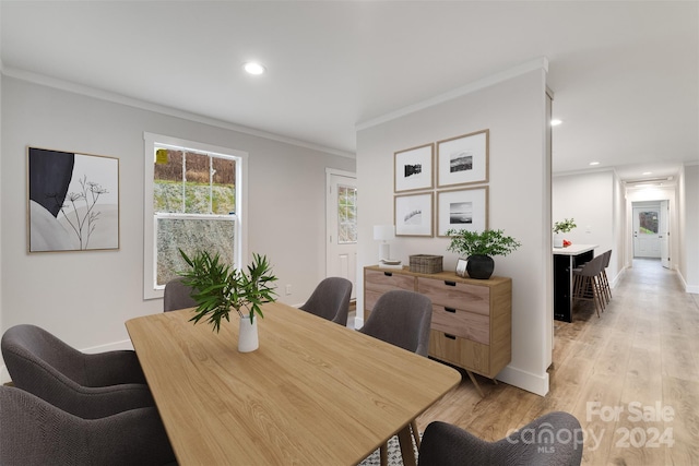 dining space featuring light hardwood / wood-style floors and ornamental molding