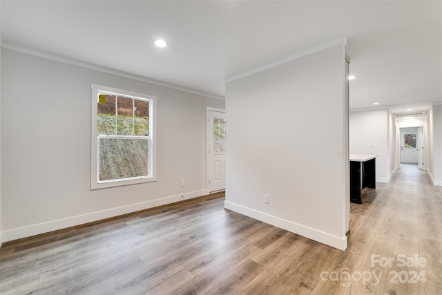 unfurnished room featuring light hardwood / wood-style floors and ornamental molding