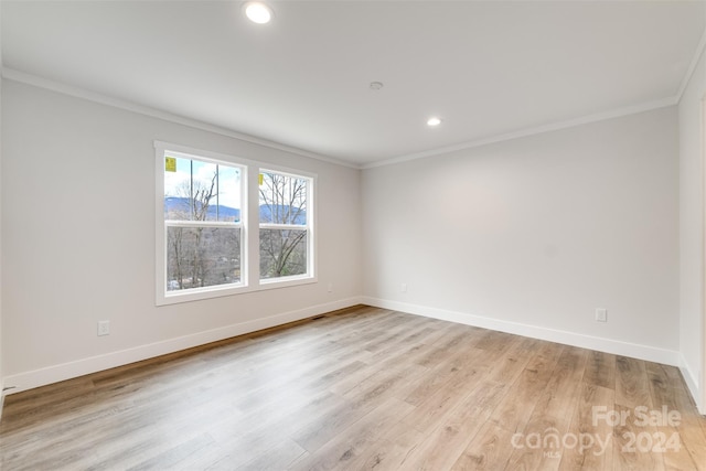 empty room with ornamental molding and light wood-type flooring