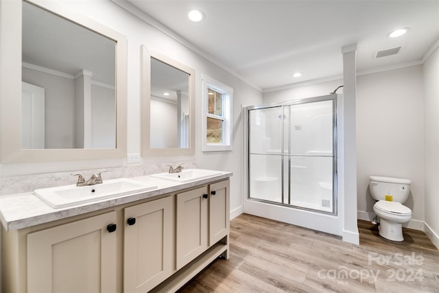 bathroom featuring crown molding, toilet, a shower with door, vanity, and hardwood / wood-style flooring