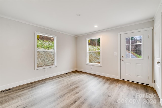 foyer featuring light hardwood / wood-style flooring, a wealth of natural light, and crown molding