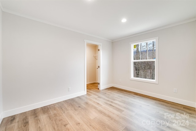 spare room with light hardwood / wood-style floors and ornamental molding