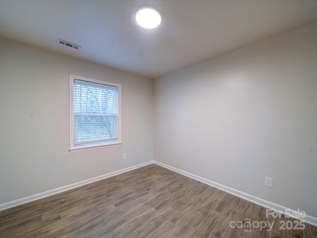 unfurnished room with wood-type flooring