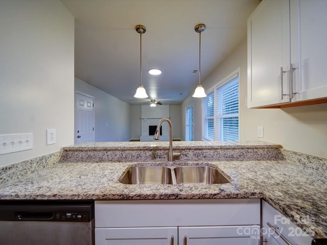 kitchen featuring dishwasher, white cabinetry, sink, hanging light fixtures, and light stone counters