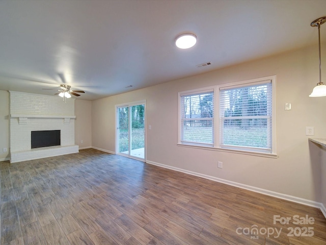 unfurnished living room featuring ceiling fan, a fireplace, and hardwood / wood-style floors