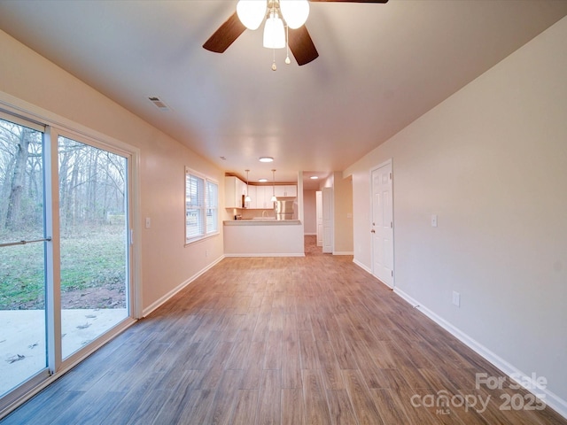 unfurnished living room with ceiling fan and hardwood / wood-style floors