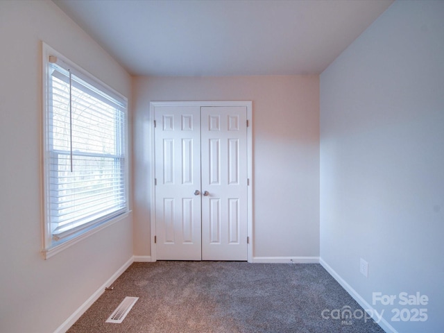 unfurnished bedroom with a closet and carpet flooring