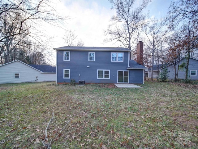 rear view of house featuring a yard, a patio, and central AC