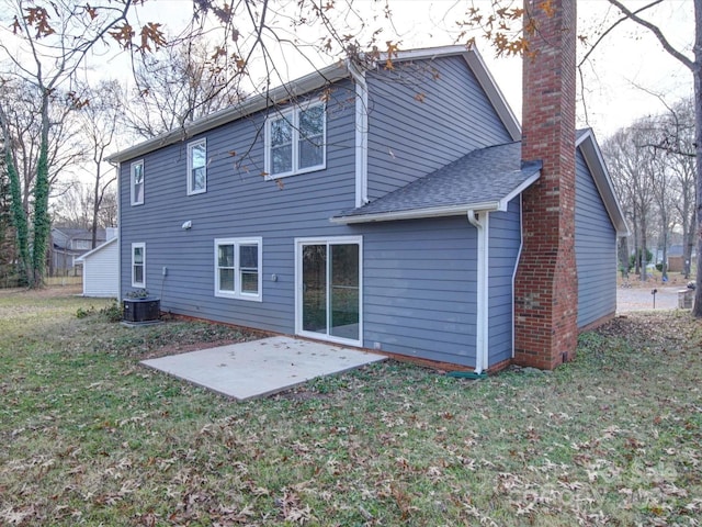 back of house with central air condition unit, a patio area, and a yard