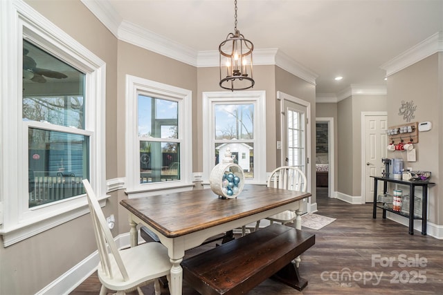 dining space featuring a wealth of natural light, dark hardwood / wood-style flooring, ornamental molding, and a notable chandelier