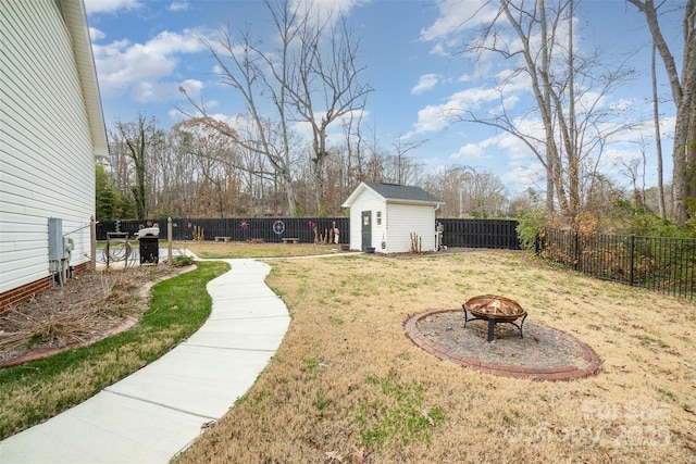 view of yard with a storage unit and an outdoor fire pit