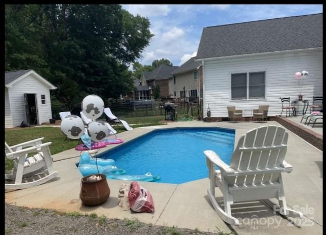 view of pool with a patio area and an outbuilding