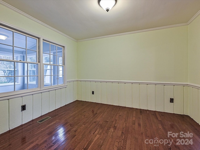 spare room with dark hardwood / wood-style flooring and ornamental molding