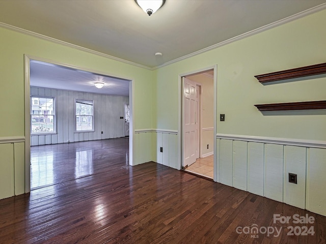 spare room with crown molding and wood-type flooring