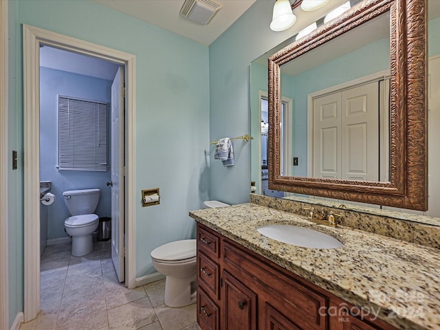 bathroom with tile patterned floors, vanity, and toilet