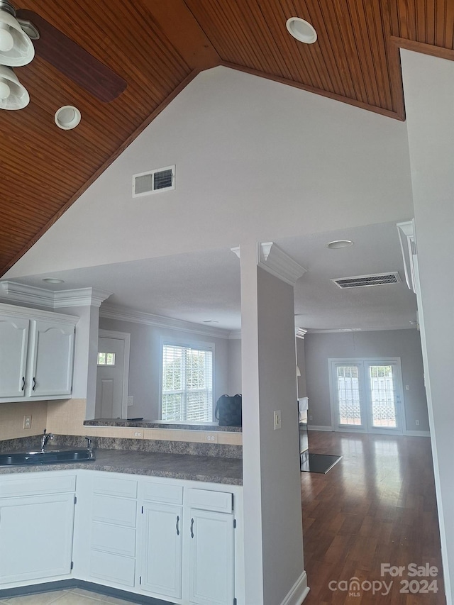 kitchen with sink, dark wood-type flooring, wooden ceiling, white cabinets, and ornamental molding