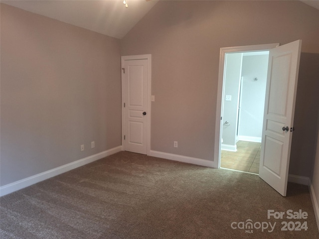 unfurnished bedroom featuring carpet floors and lofted ceiling