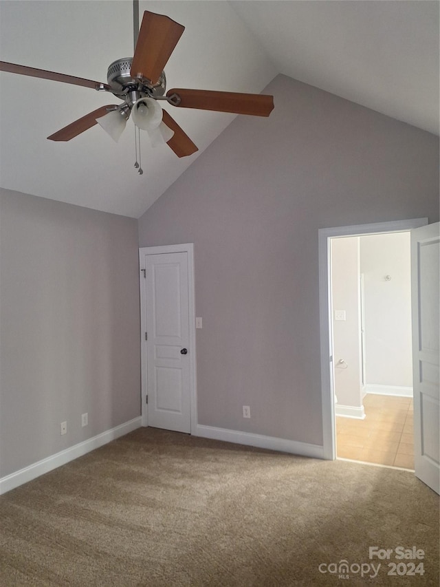 spare room with light colored carpet, high vaulted ceiling, and ceiling fan