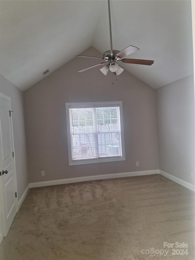 empty room with ceiling fan, carpet floors, and lofted ceiling