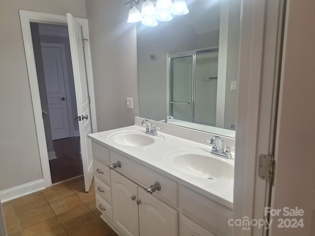 bathroom with tile patterned floors, vanity, and walk in shower