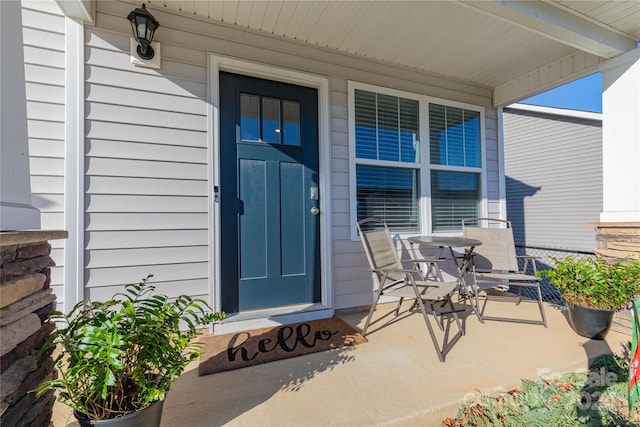 view of exterior entry featuring covered porch