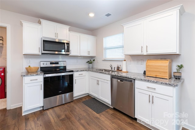 kitchen featuring light stone countertops, white cabinetry, dark wood-type flooring, and stainless steel appliances