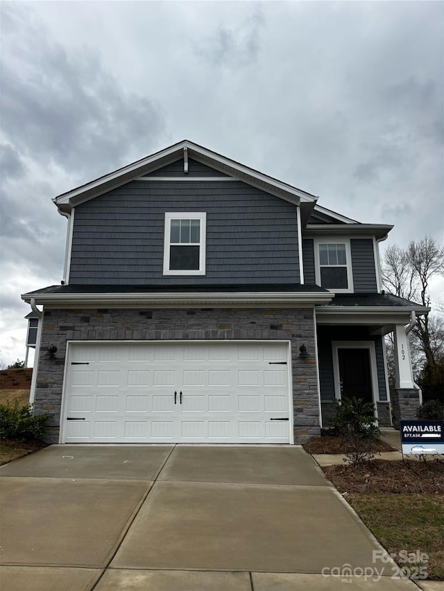 view of front of property with stone siding, concrete driveway, and an attached garage