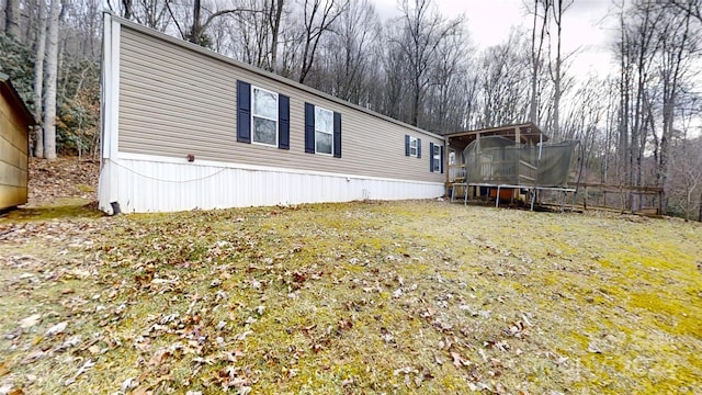 view of home's exterior featuring a lawn and a trampoline