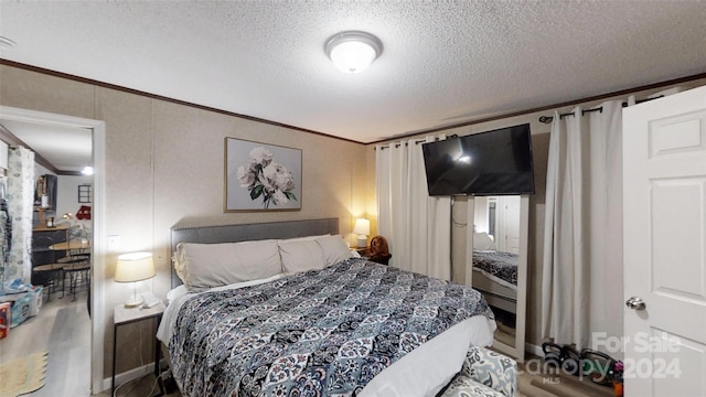 bedroom featuring crown molding and a textured ceiling