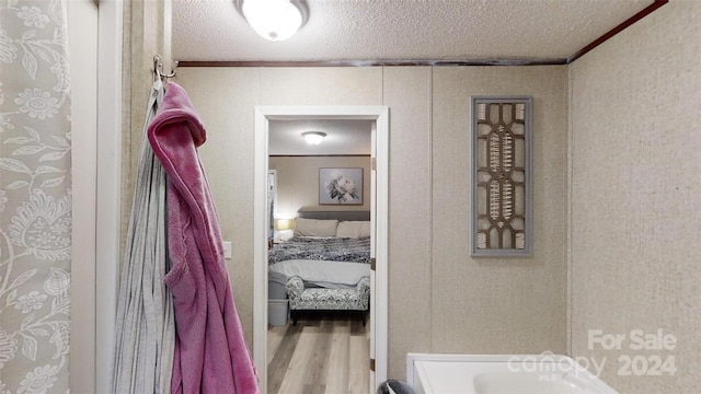 bathroom featuring wood-type flooring and ornamental molding