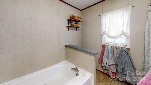 bathroom featuring tile patterned floors, crown molding, a tub, and a textured ceiling