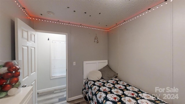 bedroom featuring wood-type flooring and a textured ceiling