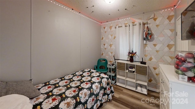 bedroom featuring tile walls, a textured ceiling, and hardwood / wood-style flooring