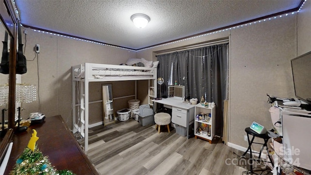 bedroom featuring wood-type flooring and a textured ceiling