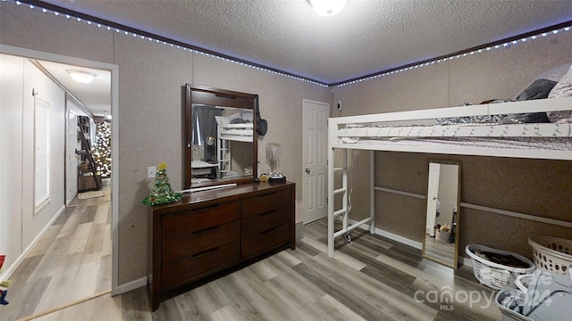 bedroom with hardwood / wood-style floors and a textured ceiling