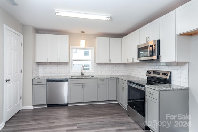 kitchen with white cabinets, sink, appliances with stainless steel finishes, and dark wood-type flooring