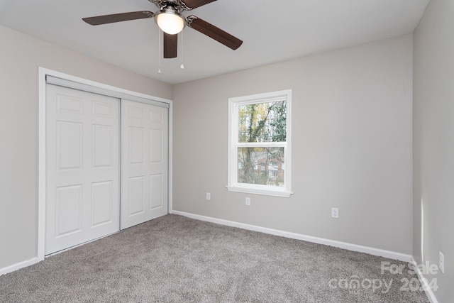 unfurnished bedroom with carpet, a closet, and ceiling fan