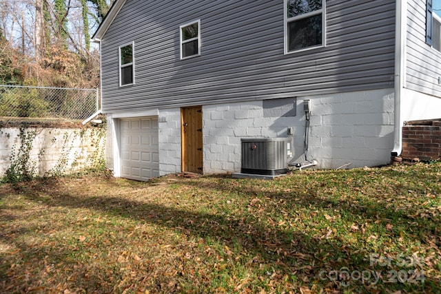 exterior space featuring a yard, central AC, and a garage