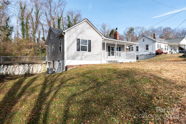 view of front of house with central AC, a porch, and a front yard