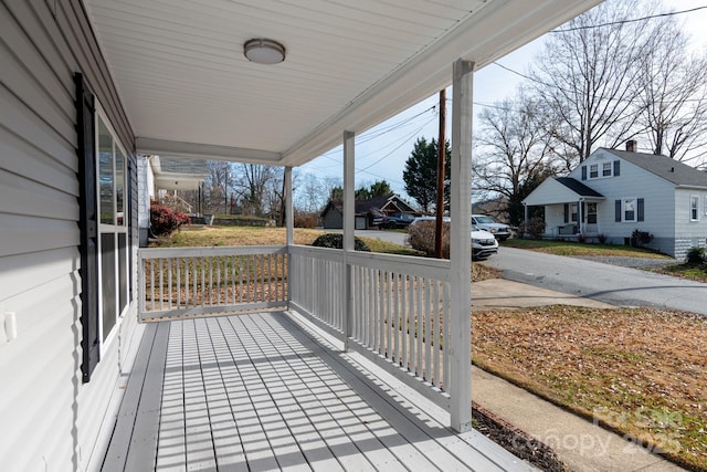 wooden deck featuring a porch and a residential view