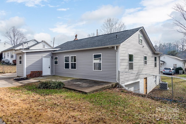 back of house with roof with shingles, a patio, central AC unit, and fence