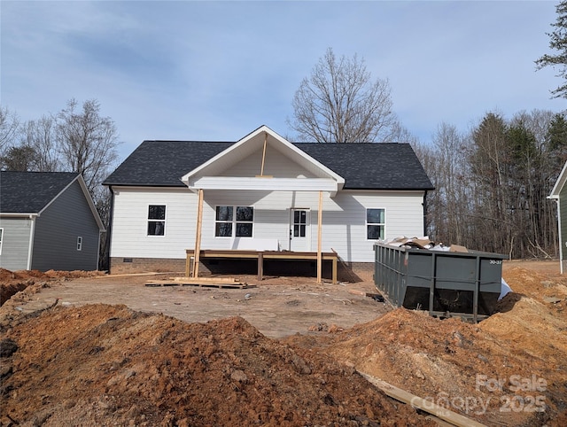 rear view of house featuring a shingled roof, crawl space, and a swimming pool