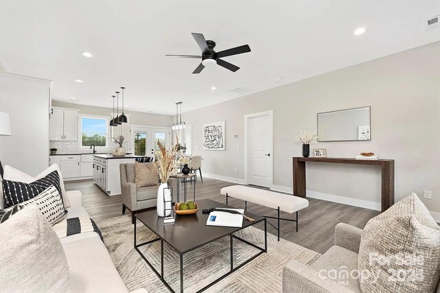 living room with light wood-type flooring, baseboards, and recessed lighting