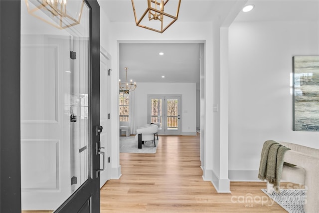 foyer featuring a chandelier, light wood-type flooring, and french doors